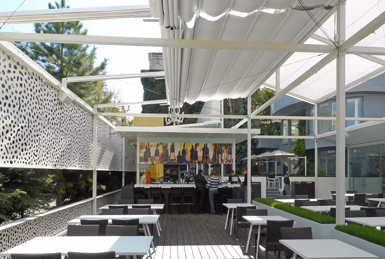 Courtyard restaurant outdoor kitchen with open dining space, surrounding architecture, and integrated cooking area