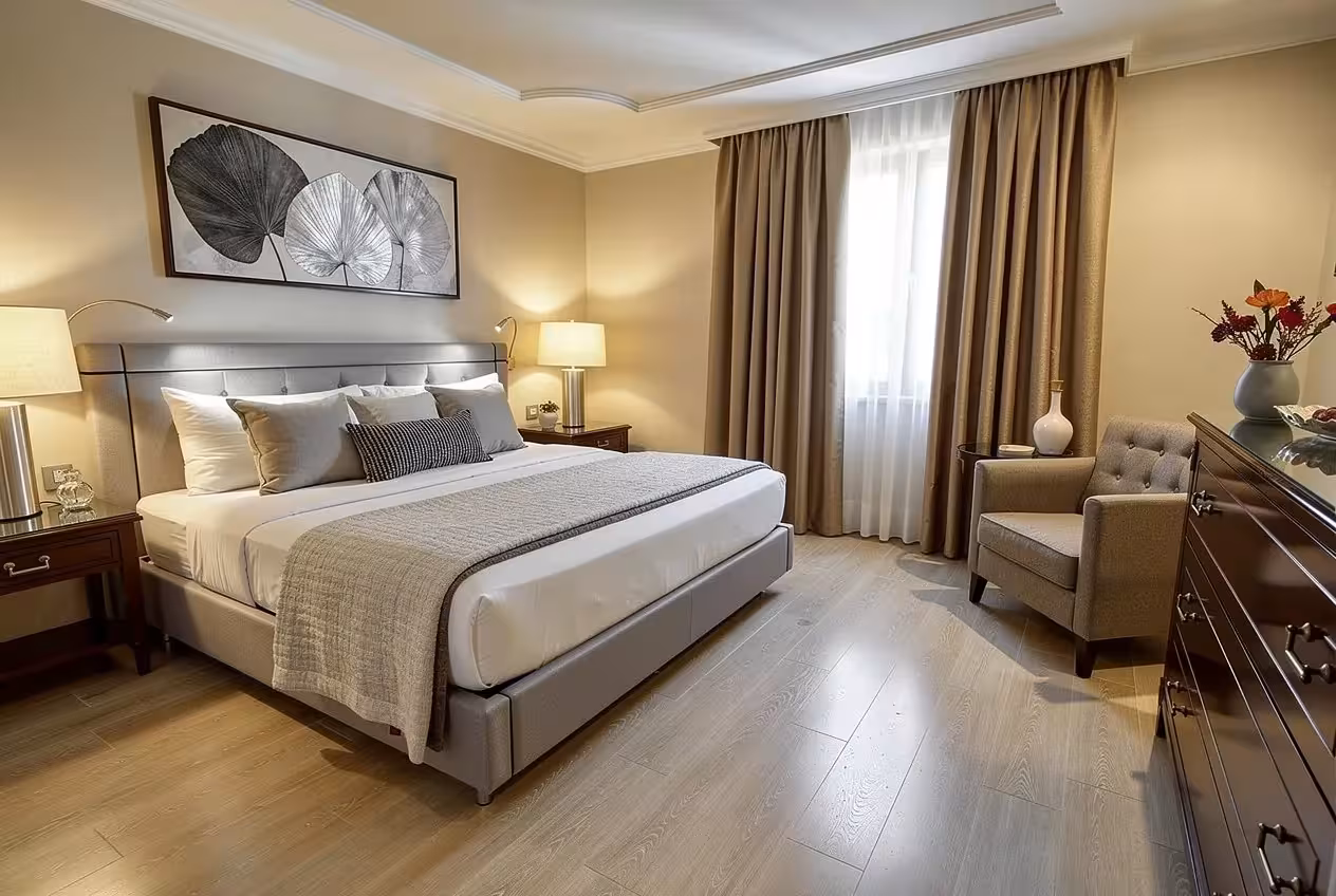 Contemporary neutral bedroom with upholstered bed, warm lighting, taupe curtains, and elegant modern decor.