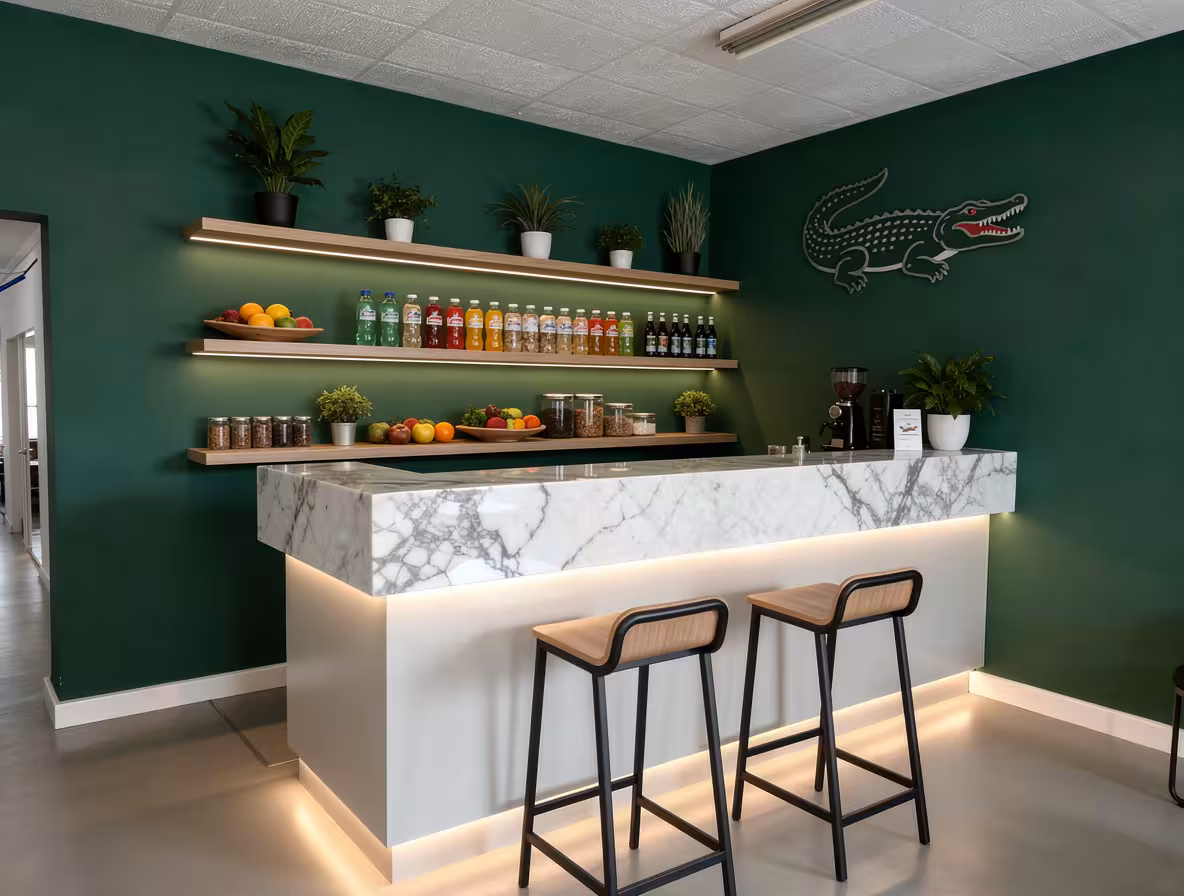 Modern office coffee bar with marble counter, green walls, floating shelves, and LED lighting