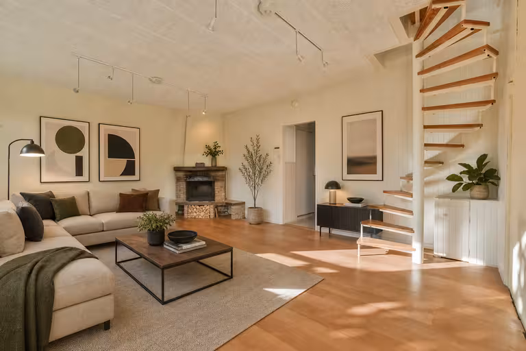 Modern Scandinavian living room with floating wood staircase, neutral sofa, fireplace, and warm wood flooring.