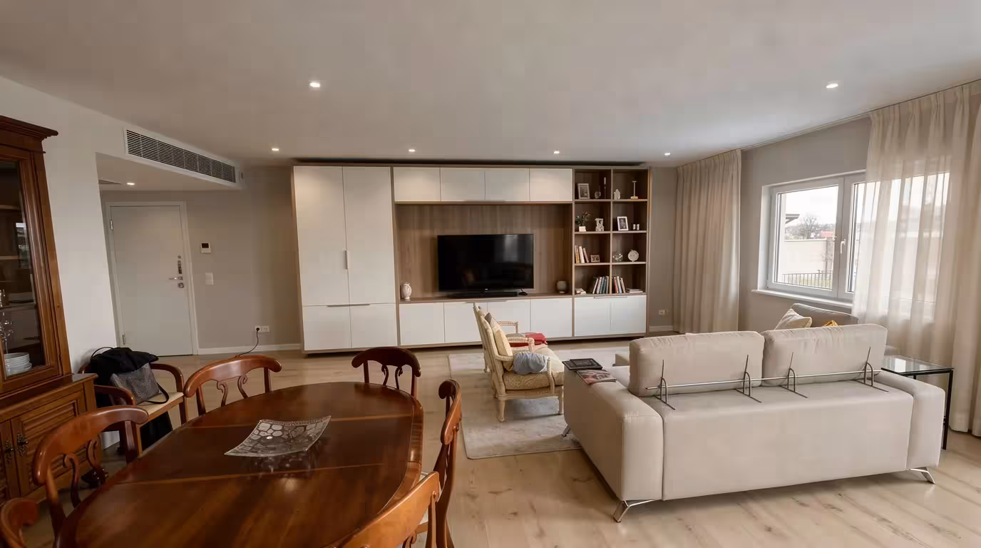 Modern Contemporary living room with beige sofa, wooden dining table, white built-in cabinets, large window with sheer curtains, neutral tones.