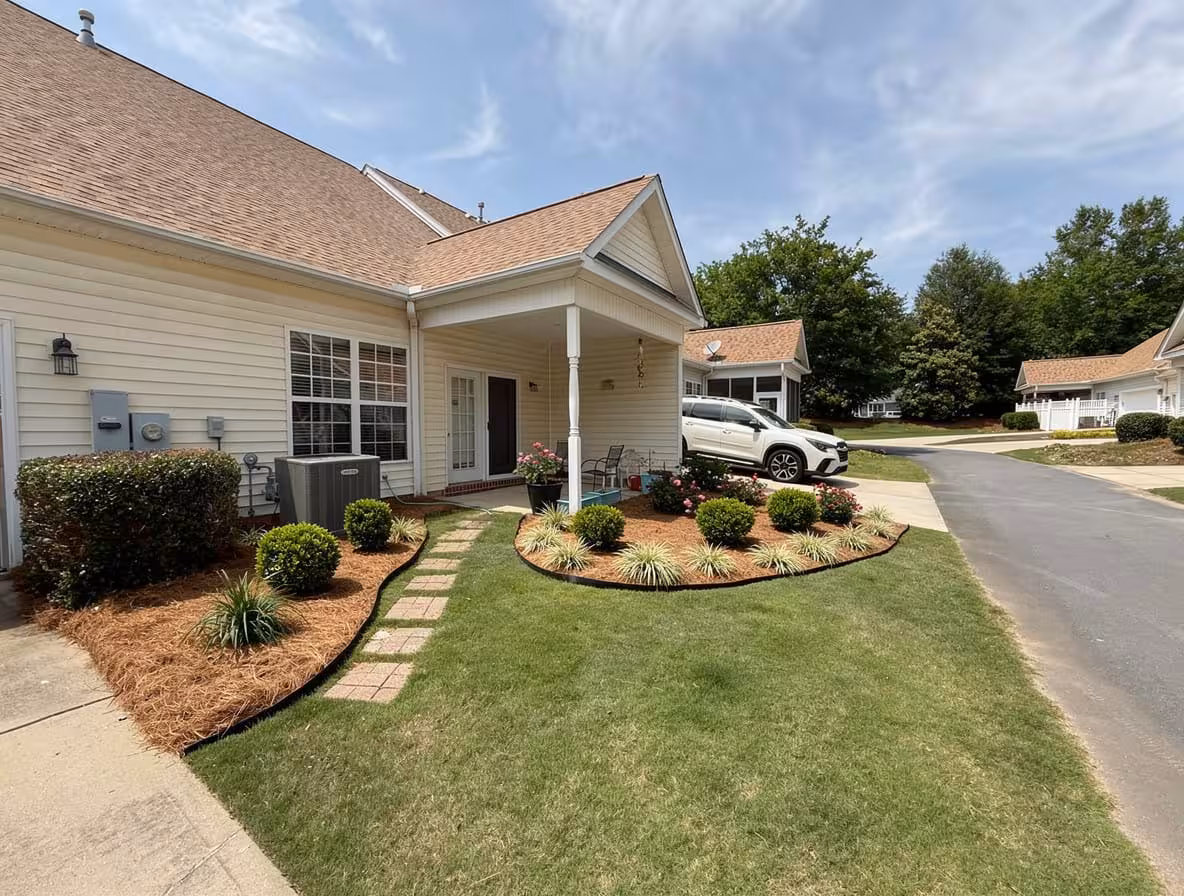Front yard with curved mulch beds, trimmed shrubs, stepping stones, and fresh lawn edging