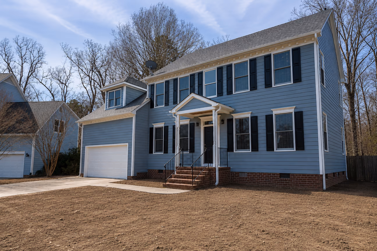 A bare soil unfinished front yard of a residential house.