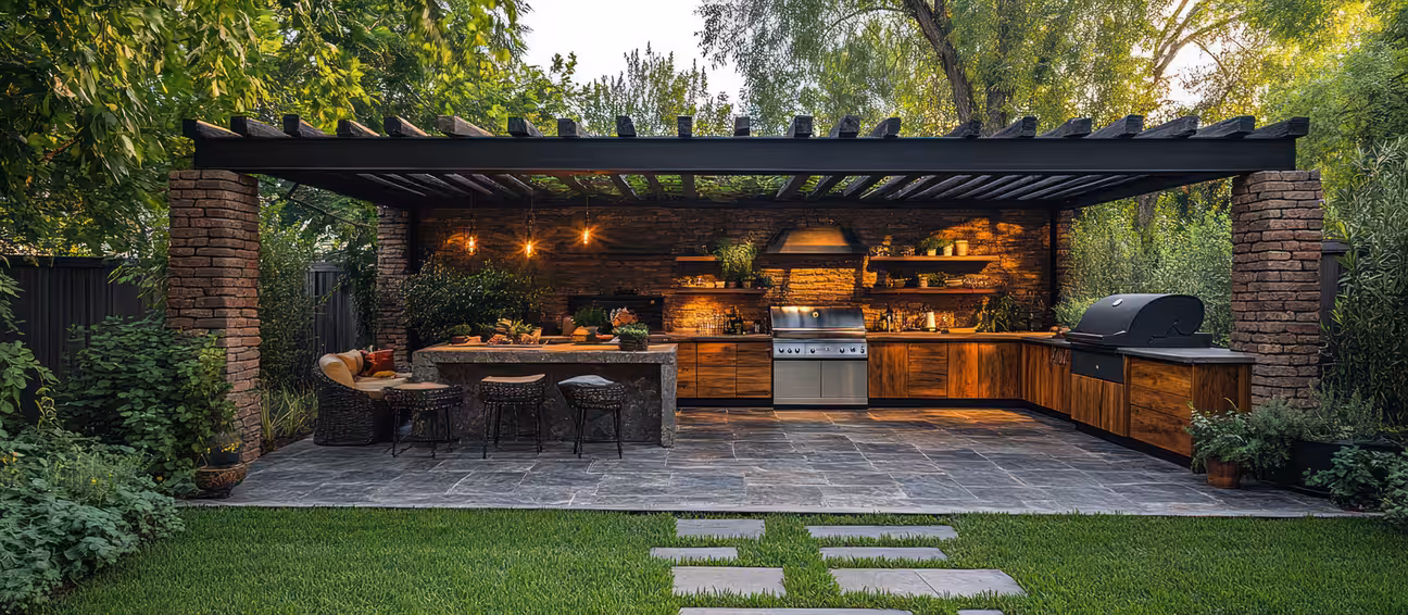 Tree-shaded modern outdoor kitchen with built-in grill, clean countertop, and open seating area