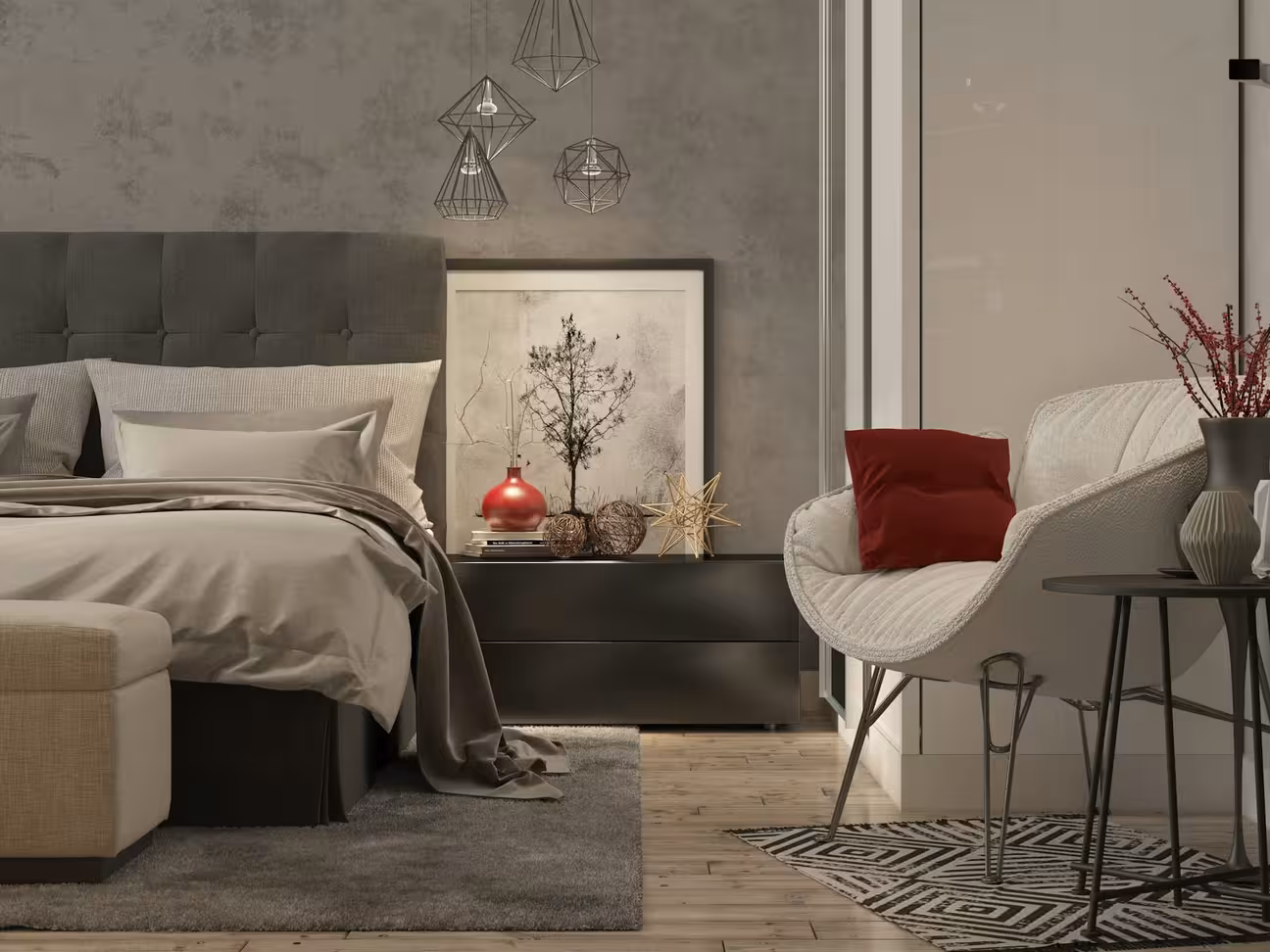 Cozy modern bedroom with a grey upholstered bed, neutral bedding, geometric pendant lights, abstract wall art, and a white accent chair with a red pillow beside a black side table on a patterned rug
