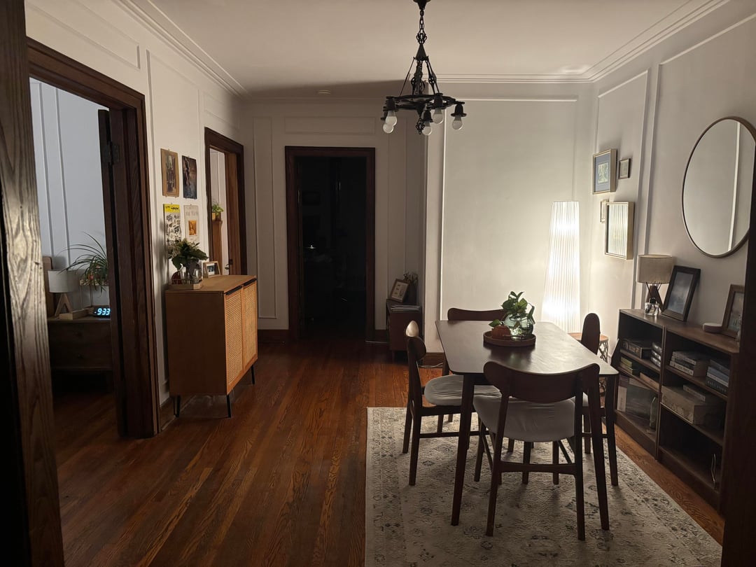 Traditional dining room with dark wood table, black chandelier, patterned rug, and dark wood flooring