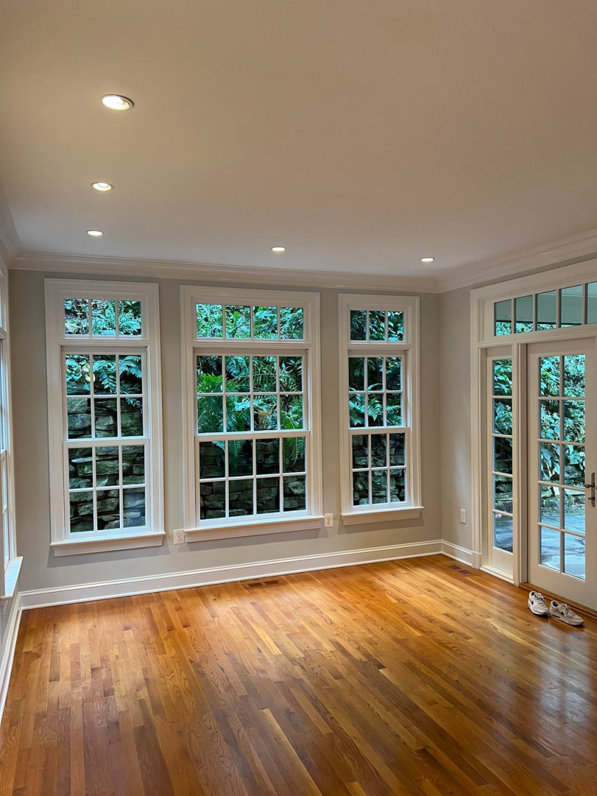 Empty room with large windows, recessed ceiling lights, hardwood flooring, and glass patio doors
