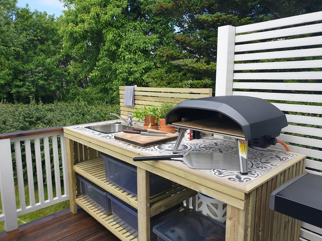 Basic deck outdoor kitchen with unfinished wood prep station and pizza oven