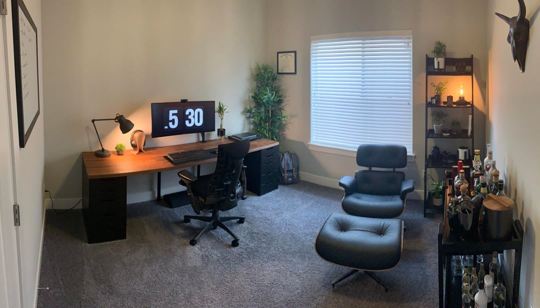 Simple home office with desk setup, lounge chair, and neutral walls