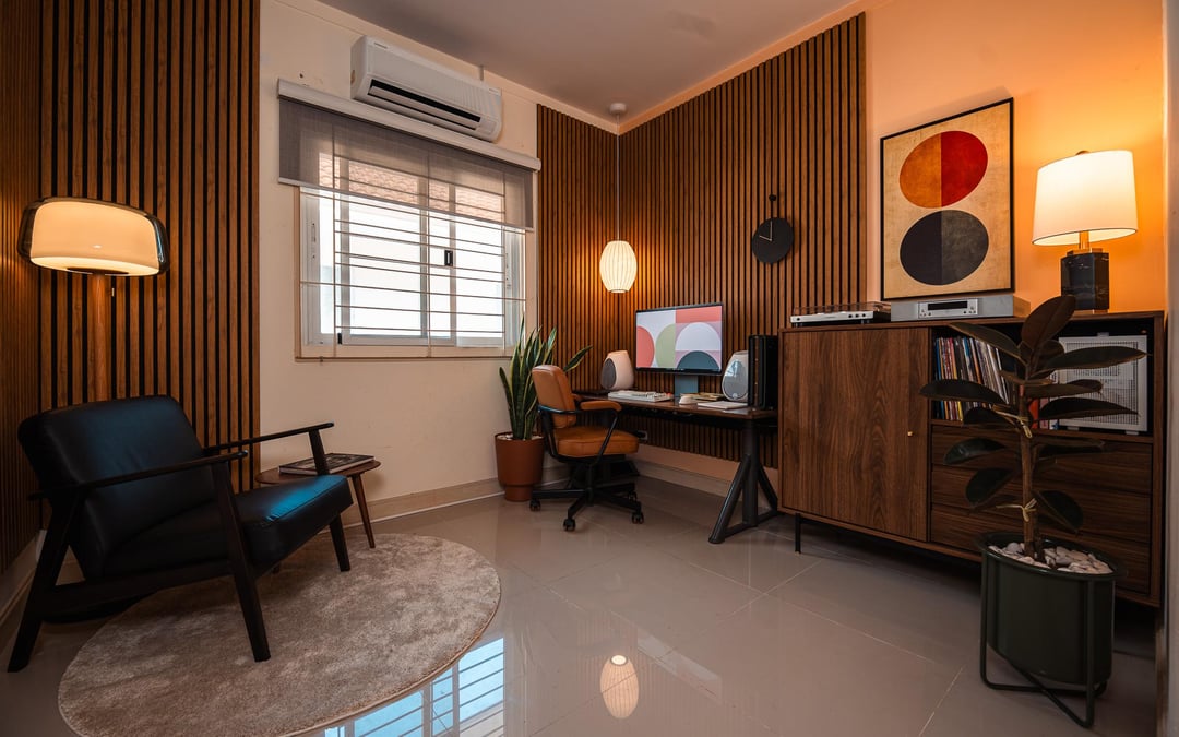 Modern home office with wood slat accent wall, desk setup, and neutral decor.