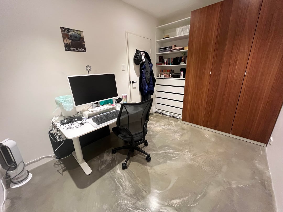 Small minimalist home office with white desk and polished concrete flooring