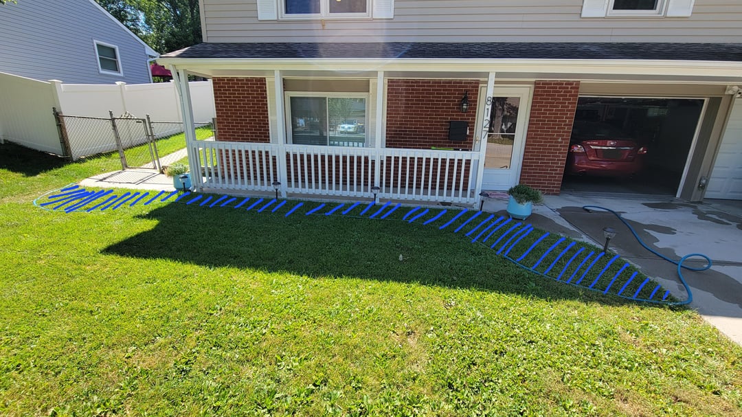Plain front yard with grass lawn and blue-marked landscaping outline near porch